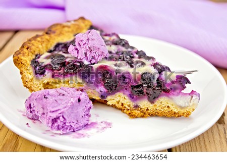 Piece of pie with blueberries, ice cream and spoon and in plate, napkin on a wooden boards background