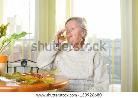 Senior woman drinking juice in her room. MANY OTHER PHOTOS FROM THIS SERIES IN MY PORTFOLIO.