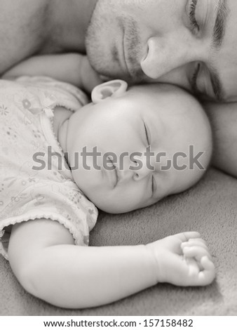 Father sleep with his baby.