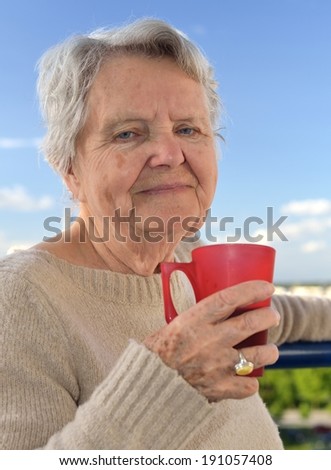 Senior woman drinking tea - outdoors. MANY OTHER PHOTOS WITH THESE MODEL IN MY PORTFOLIO.
