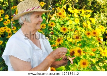 Senior woman in garden full of flowers. MANY OTHER PHOTOS FROM THIS SERIES IN MY PORTFOLIO.