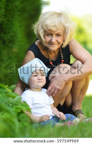 Grandmother care baby in garden.