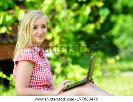 Young attractive woman lying on lawn with laptop.  MANY OTHER PHOTOS FROM THIS SERIES IN MY PORTFOLIO.