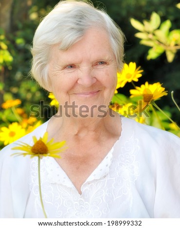 Senior woman in garden full of flowers.  MANY OTHER PHOTOS FROM THIS SERIES IN MY PORTFOLIO.