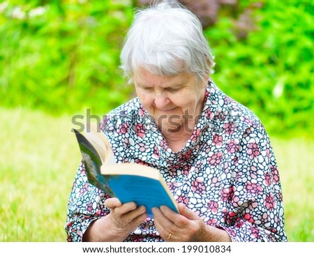 Senior woman reading book in park.  MANY OTHER PHOTOS FROM THIS SERIES IN MY PORTFOLIO.
