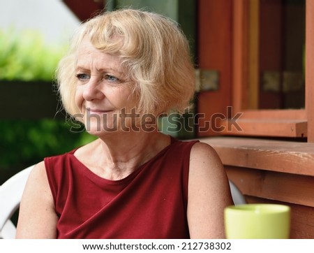 Mature, blonde woman in garden,  MANY OTHER PHOTOS FROM THIS SERIES IN MY PORTFOLIO.