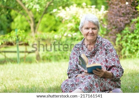 Senior woman reading book in park. MANY OTHER PHOTOS FROM THIS SERIES IN MY PORTFOLIO.