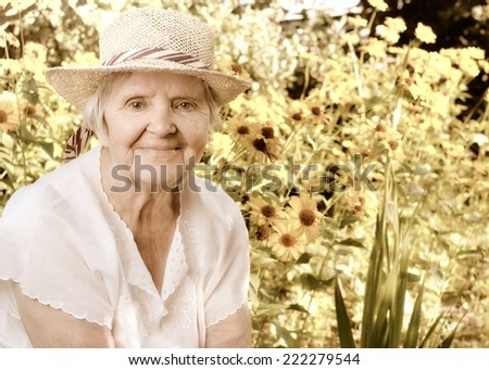 Senior woman in garden full of flowers. Vintage style.