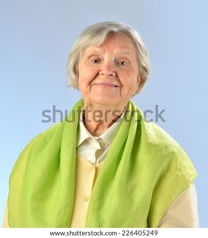 Senior happy woman with grey hairs against blue background.