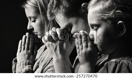 Praying family. Man, woman and child. MANY OTHER PHOTOS FROM THIS SERIES IN MY PORTFOLIO.