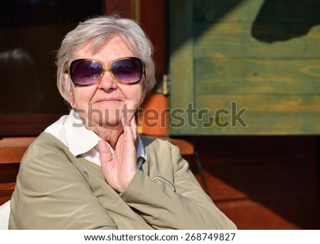 Senior woman on the veranda of his home. MANY OTHER PHOTOS FROM THIS SERIES IN MY PORTFOLIO.