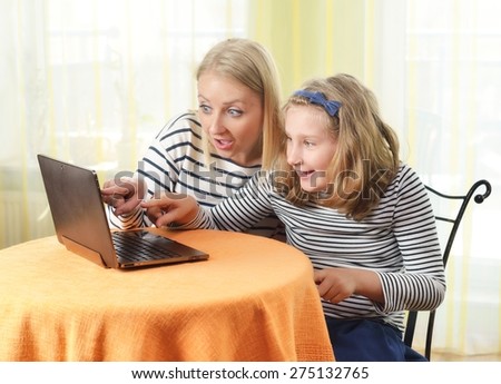 Happy girl and grandmother using a laptop in home. MANY OTHER PHOTOS FROM THIS SERIES IN MY PORTFOLIO.