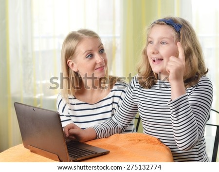 Happy girl and grandmother using a laptop in home. MANY OTHER PHOTOS FROM THIS SERIES IN MY PORTFOLIO.