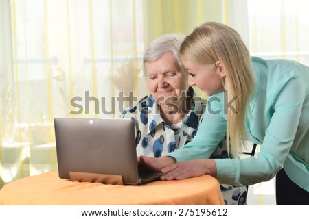 Senior woman with her caregiver in home using laptop. MANY OTHER PHOTOS FROM THIS SERIES IN MY PORTFOLIO.