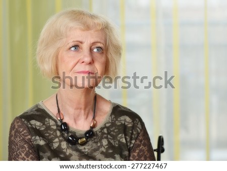 Mature woman thoughtful in her apartment. MANY OTHER PHOTOS FROM THIS SERIES IN MY PORTFOLIO.