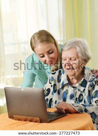 Senior woman with her caregiver in home using laptop. MANY OTHER PHOTOS FROM THIS SERIES IN MY PORTFOLIO.