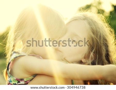 Two sisters Cuddled up together. Back lighting sunlight. MANY OTHER PHOTOS FROM THIS SERIES IN MY PORTFOLIO.