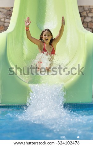 Girl rides on the water slide in a water park.