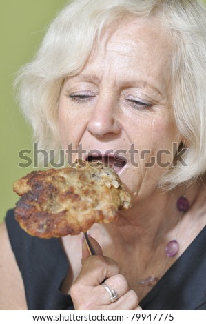 Blonde woman eating meat pork
