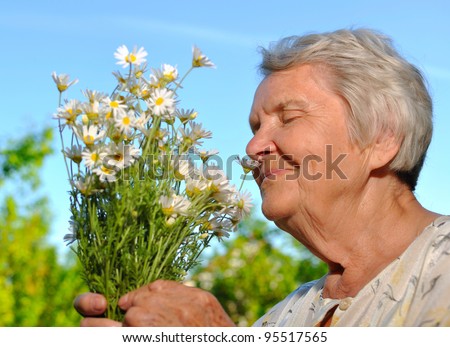 Senior smelling flowers on blue sky. MANY OTHER PHOTOS WITH THESE MODELS IN MY PORTFOLIO - stock-photo-senior-smelling-flowers-on-blue-sky-many-other-photos-with-these-models-in-my-portfolio-95517565