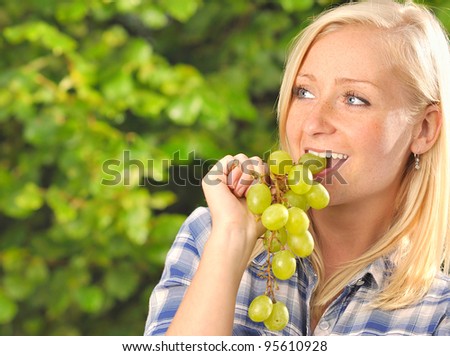 Young woman eating grapes. MANY OTHER PHOTOS WITH THESE MODEL IN MY PORTFOLIO.