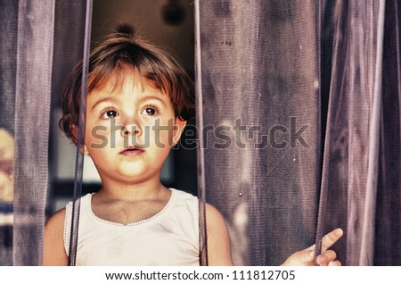 Sad face expression of Baby behind the Curtain - Italy