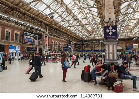 LONDON - SEP 30: Passengers wait for train arrivals at Victoria Station on a crowded Sunday afternoon. September 30, 2012.