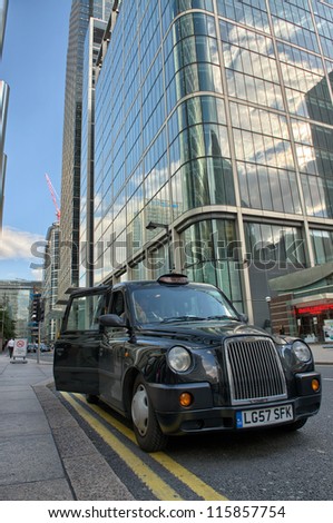 LONDON - SEP 27: A taxi awaits for customer to come inside in Canary Wharf area, September 27, 2012 in London. Canary Wharf  is a large business and shopping development in East London.