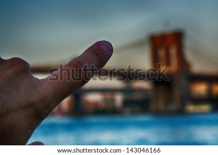 Tourist finger pointing at a Brooklyn Bridge Tower - New York City.