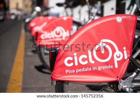 PISA, ITALY - JUL 2: Ciclopi bikes parked at a bike station, July 2, 2013 in Pisa, Italy. This new public bike system will help solve city traffic issue