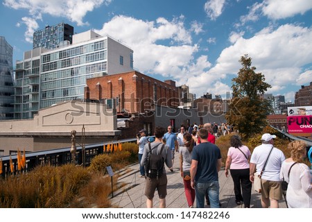 NEW YORK CITY - JUN 15: People walk and relax along the High Line on June 15, 2013. The High Line is a popular linear park built on the elevated train tracks above Tenth Ave in New York City.