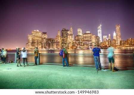 New York City at night in summer. View of Manhattan skyline from Brooklyn Bridge Park.