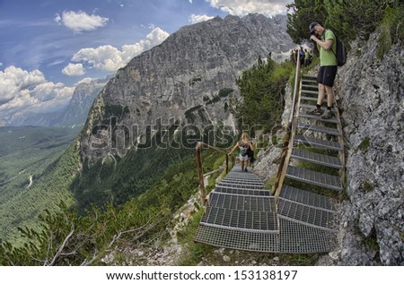 DOLOMITES, ITALY - AUG 17: Tourists on a mountain trail, August 17, 2013 in Italy. Millions of people enjoy the breathtaking alpine views in summer season.