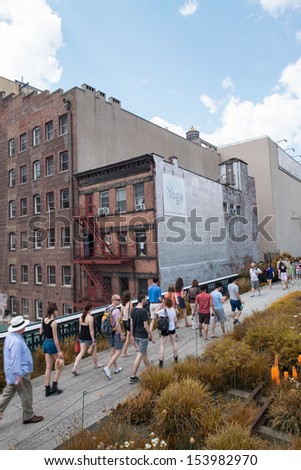 NEW YORK CITY - JUN 15: People walk and relax along the High Line on June 15, 2013. The High Line is a popular linear park built on the elevated train tracks above Tenth Ave in New York City.