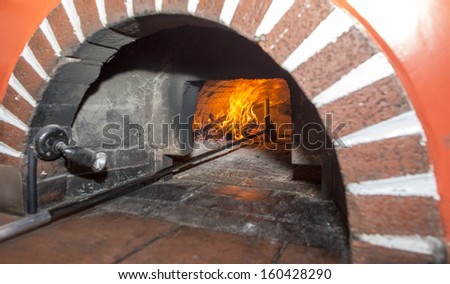 Stone wood oven with fire burning.