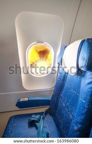 Window Seat in an airplane cabin with sunset outside.