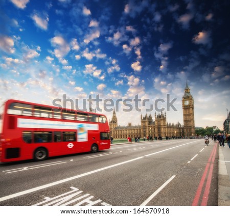 Red Double Decker Bus speeding up to Big Ben Tower on Westminster Bridge, London - UK.