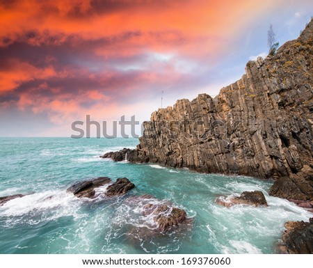 Cliffs at sunset over crystal clear ocean waters.