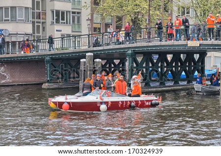 AMSTERDAM - APRIL 30: Amsterdam canals full of boats and people in orange during the celebration of queensday on April 30, 2013 in Amsterdam, The Netherlands.