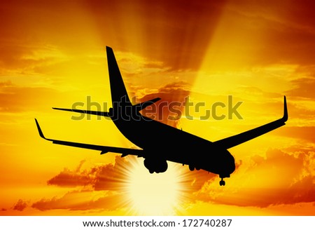 Silhouette of a airplane. Aircraft flying in the sky at sunset.