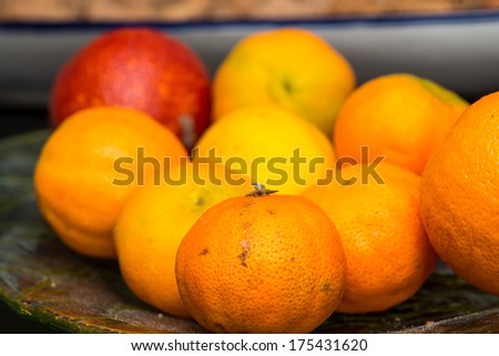 Oranges and red apple on a fruit tray.
