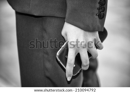 Hand of woman holding a mobile phone during a meeting.