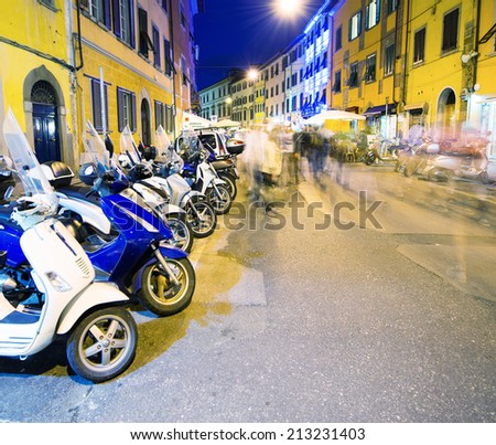 Row of motorbikes parked in Pisa Downtown.