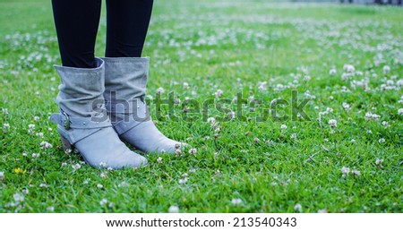 Woman boots on a green garden.