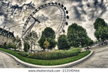 LONDON - SEP 29, 2013: Tourists visit London Eye Wheel. The entire structure is 135 metres (443 ft) tall and the wheel has a diameter of 120 metres (394 ft).