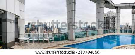 HONG KONG - MAY 12, 2014: Stunning panoramic view of Hong Kong Island and Kowloon on a cloudy day from tower roof. Last year HK hosted more than 54 million visitors, most of them from the mainland.