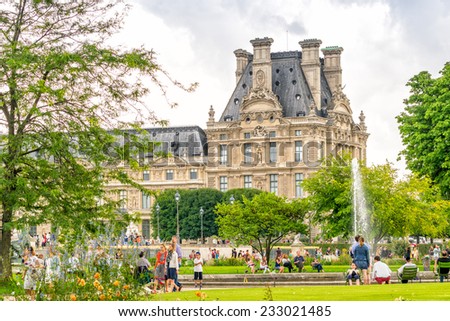 PARIS - JULY 20, 2014: Tourists walk along Tuileries Gardens in Paris. French capital is visited by more than 30 million people annually.