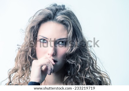 Close-up portrait of beautiful seductive woman biting finger.