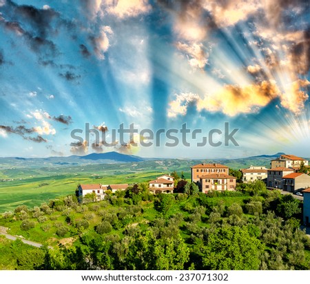 Italian landscape, Tuscany meadows and homes at sunset.