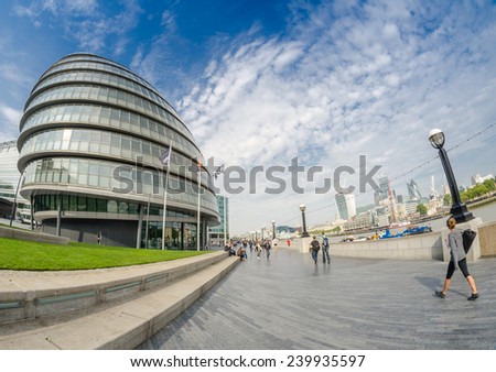 LONDON - SEPTEMBER 27, 2013: Tourists walk along river Thames near City Hall. The city is visited by more than 30 million people every year.